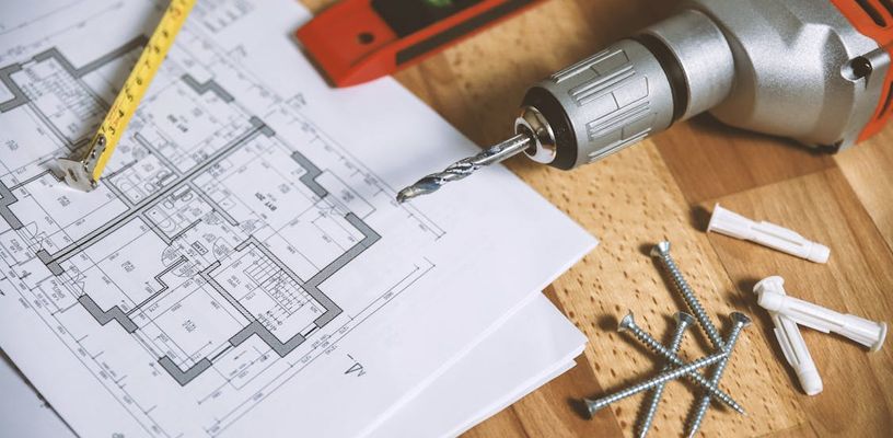 Free Floor Plan, drill, screws and a level on a wooden table.